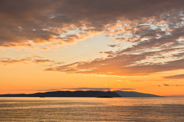 Fototapeta na wymiar Sun is setting behind Skiathos island, view from Kastani Mamma Mia beach, island of Skopelos, Greece