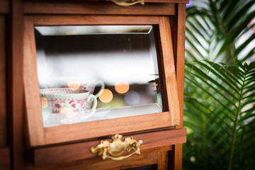 White tea cup in old wooden cabinet.  Vintage Style and bokeh.