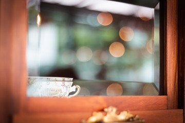 White tea cup in old wooden cabinet.  Vintage Style and bokeh.