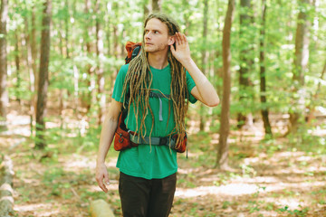 Male hiker listening for something in the forest