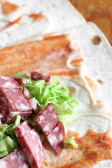 Preparation of shawarma. Meat with vegetables in a bread cake. Fast food.