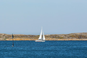 Fototapeta premium Sailingboat at a rocky coastline