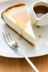 Slice of Classical New York Cheesecake with caramel sauce. Closeup view, selective focus