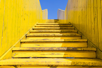 Yellow stairs of the wooden Luchtsingel bridge, Rotterdam, Netherlands with blue sky in summer