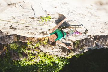 The girl climbs the rock.