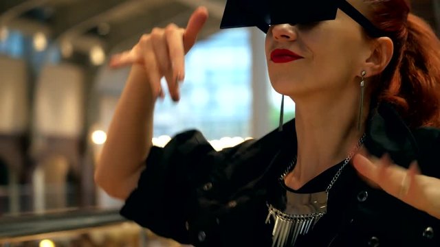 Pretty fashion woman like superstar dancing and has a fun in mall with square sunglasses close-up