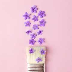 Brush repainting by flowers pink background. Minimal spring, summer romantic concept, flat lay, punchy pastel