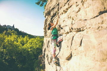 The girl climbs the rock.
