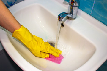 Sink cleaning with yellow gloves