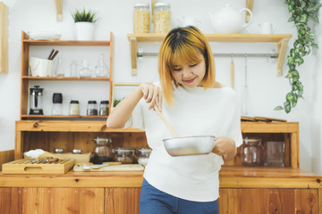 Asian woman making healthy food standing happy smiling in kitchen preparing salad. Beautiful cheerful Asian young woman at home. Healthy food dieting and healthy lifestyle cooking at home Concept.