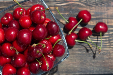 red cherries in a glass vase on a dark background