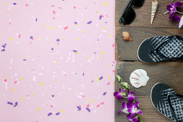Table top view aerial image of summer & travel beach holiday in the season background concept.Flat lay essential objects plank wooden for traveler on modern pink paper and copy space with confetti.