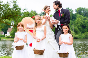 Wedding bride and groom with flower children or bridesmaid and white doves of peace