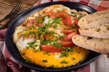 Homemade breakfast fried egg with tomato.