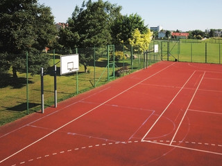 Modern basketball court under the open sky with artificial red coating. Location of team sports events. Physical education of citizens. Healthy lifestyle. Urban infrastructure for recreation, interest