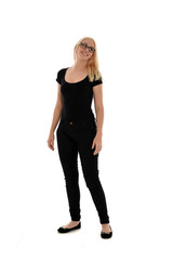 full length portrait of blonde girl wearing black clothing, isolated on white background.