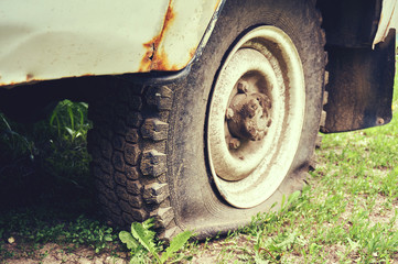 Flat tire on an old rusty SUV close-up.