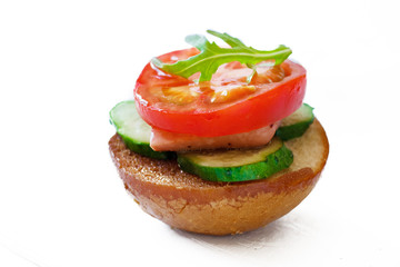Sandwiches with sausages, cucumbers and tomatoes and arugula on a white background isolated