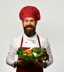 Man with beard isolated on white background. Chef holds vegetables.