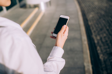 The young woman uses the smartphone