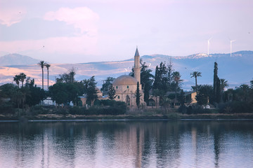 Architecture of Hala Sultan Tekke with cloudy sky and reflections