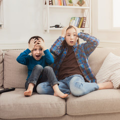 Frightened children watching TV at home