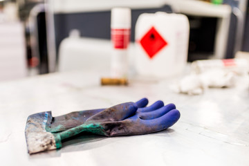 Dirty blue protective glove on white table.
