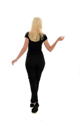 full length portrait of blonde girl wearing black clothing, isolated on white background.