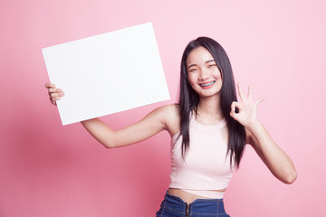 Young Asian woman show OK with  white blank sign.