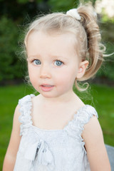 Portrait of little adorable blond girl with blue eyes