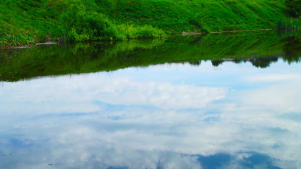 The sky and clouds are reflected in the lake.Beautiful view.