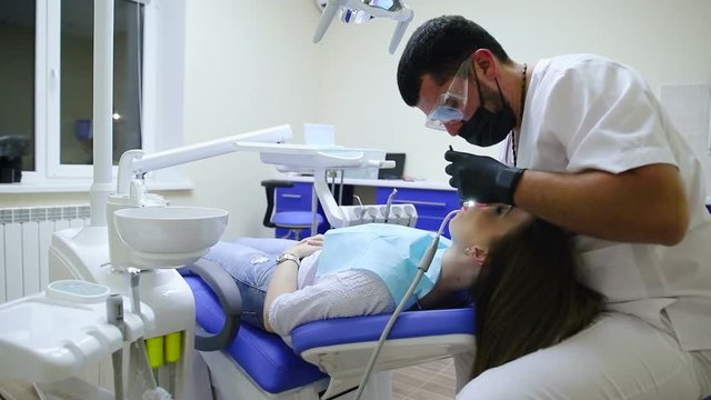 The dentist treats the teeth to the patient. Slow motion