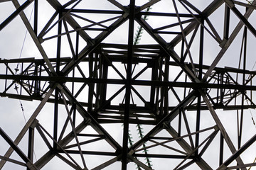 symmetrical pattern formed by a bottom view of a steel grid-shaped power line support