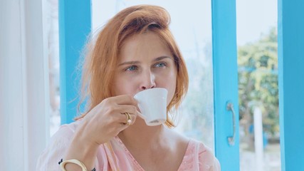 Portrait of young pretty woman drinking coffee