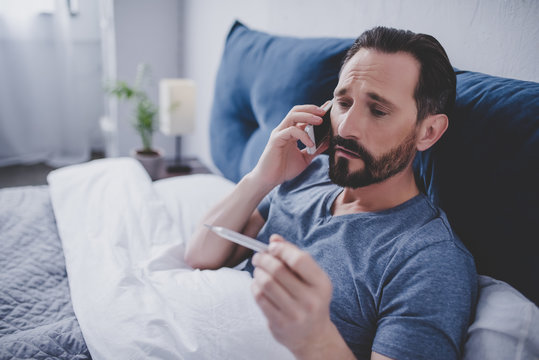 Sick Man Holding Thermometer