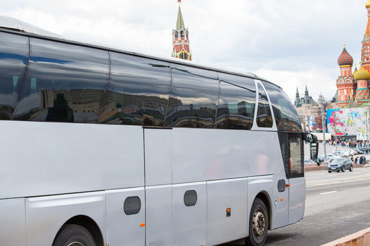 White excursion bus moves in the center of Moscow