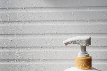 Fototapeta na wymiar Water drop on liquid soap dispenser pump during bath time