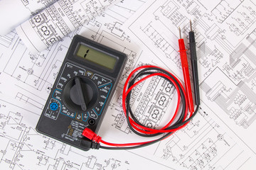 Electrical engineering drawings and digital multimeter.
