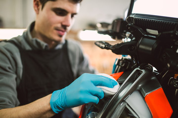 Fototapeta na wymiar Mechanic polishing and cleaning a motorcycle