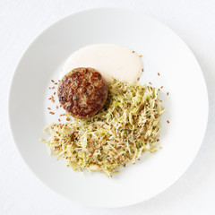turkey meatball with braised cabbage and yogurt based sauce decorated with linen seeds 