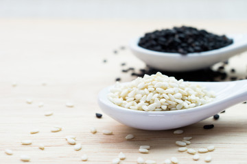 The white and black sesame on the wooden table.