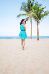 Fototapeta na wymiar Young beautiful asian woman is walking on the beach