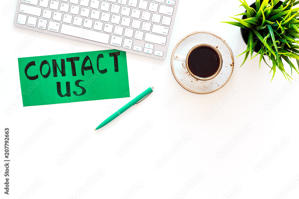 Poster frame contact us. lettering contact us on office work desk with computer on white background top vie