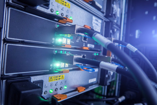 Abstract of modern high tech internet data center room with rows of racks with network and server hardware.