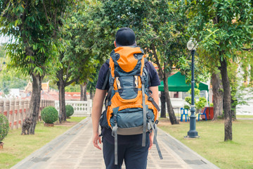 Man with backpack walking in a park