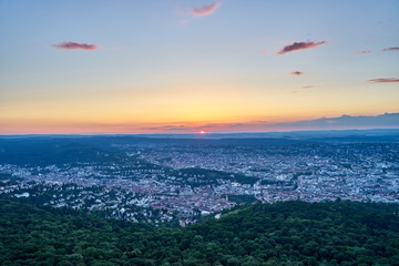 Night falls over Stuttgart City in Germany / Turning on the lights in the city