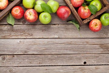 Green and red apples in wooden box