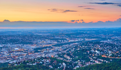 Night falls over Stuttgart City in Germany / Turning on the lights in the city