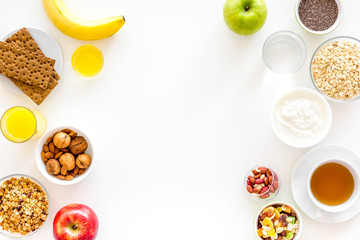 Ingredients for healthy breakfast. Fruits, oatmeal, yogurt, nuts, crispbreads, chia on white background top view copy space