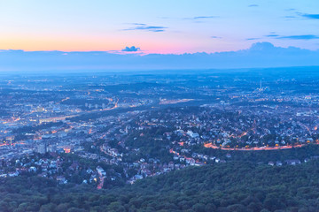 Night falls over Stuttgart City in Germany / Turning on the lights in the city